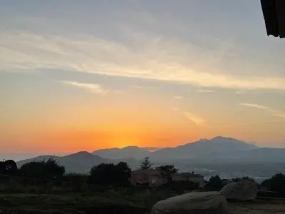 a sunset with mountains in the background at Magnifique appartement T2 in Cuttoli-Corticchiato