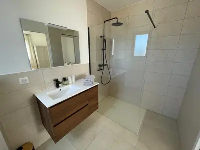a bathroom with a sink and a shower with a mirror at Magnifique appartement T2 in Cuttoli-Corticchiato