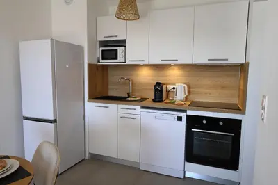 a kitchen with white cabinets and a white refrigerator at La Pépite Corse - Magnifique T2 cabine vue mer in Pianottoli-Caldarello
