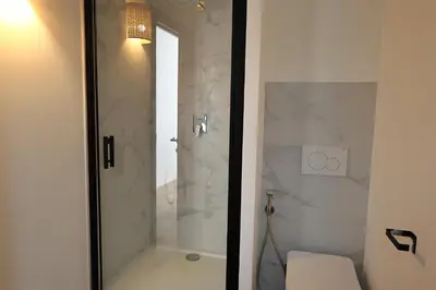 a bathroom with a glass shower with a toilet at La Pépite Corse - Magnifique T2 cabine vue mer in Pianottoli-Caldarello
