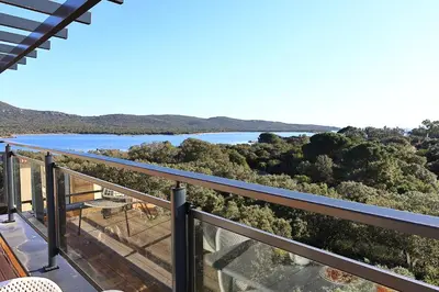 a balcony with a view of a lake at La Pépite Corse - Magnifique T2 cabine vue mer in Pianottoli-Caldarello