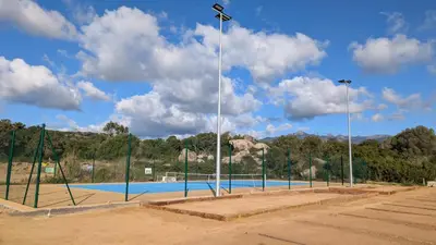 a tennis court with lights on the side of it at La Pépite Corse - Magnifique T2 cabine vue mer in Pianottoli-Caldarello