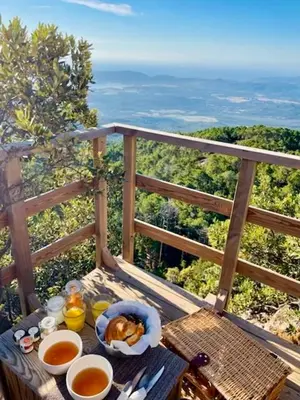 a table with food and drinks on a balcony at Cocoon Village in Porto-Vecchio