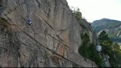 a person rappelling off of a rock wall at Cocoon Village in Porto-Vecchio