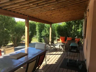 a patio with a table and chairs on a deck at Appartement design in Porto-Vecchio