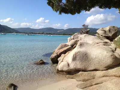 a beach with some rocks and the water at Appartement design in Porto-Vecchio