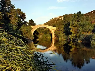 a bridge over a river with reflections in the water at Appartement design in Porto-Vecchio