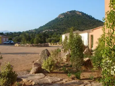 a building with a mountain in the background at Appartement design in Porto-Vecchio
