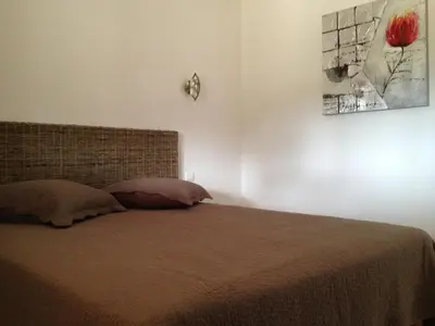 a bedroom with a bed and a painting on the wall at Appartement design in Porto-Vecchio