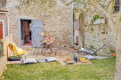 a patio with a table and chairs in the yard at Casa Pruno in Pruno