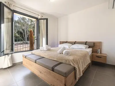 a bedroom with a bed and a large window at Apartment Foce Dell Edera-2 by Interhome in Bonifacio