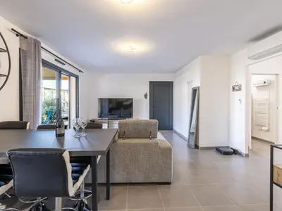 a dining room and living room with a table and chairs at Apartment Foce Dell Edera-2 by Interhome in Bonifacio