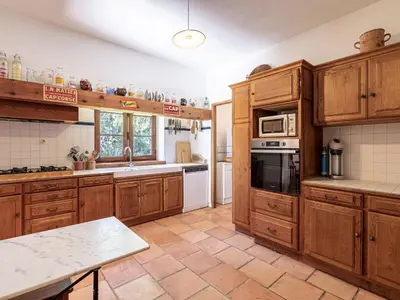 a large kitchen with wooden cabinets and appliances at Holiday Home Casa Gialla by Interhome in Arraggio
