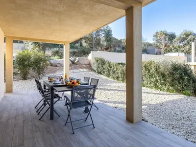 a patio with a table and chairs on a porch at Apartment Foce Dell Edera-1 by Interhome in Bonifacio