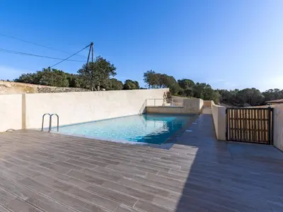 a swimming pool on a patio with a fence at Apartment Foce Dell Edera-1 by Interhome in Bonifacio