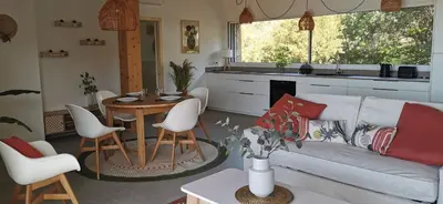 a living room with a couch and a table at Casa PETRA, typique en pierres au coeur du maquis, 2 pers, Piscine in Pietrosella