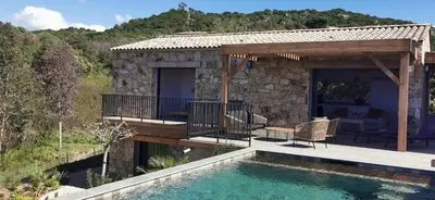a house with a deck and a swimming pool at Casa PETRA, typique en pierres au coeur du maquis, 2 pers, Piscine in Pietrosella