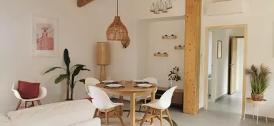 a dining room with a table and white chairs at Casa PETRA, typique en pierres au coeur du maquis, 2 pers, Piscine in Pietrosella
