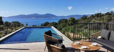 a patio with a pool and a table and chairs at Casa PETRA, typique en pierres au coeur du maquis, 2 pers, Piscine in Pietrosella