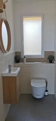 a bathroom with a toilet and a sink and a window at Casa PETRA, typique en pierres au coeur du maquis, 2 pers, Piscine in Pietrosella