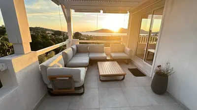 a patio with a couch and a table on a balcony at Superbe maison F5 avec vue mer - Plage à 5 min - Climatisation - Wifi gratuit in Grosseto-Prugna