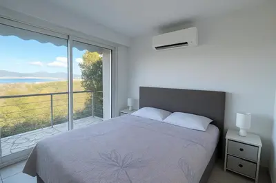 a bedroom with a bed and a large window at Superbe maison F5 avec vue mer - Plage à 5 min - Climatisation - Wifi gratuit in Grosseto-Prugna