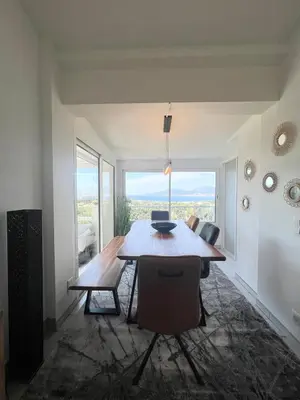 a living room with a dining room table and a view at Superbe maison F5 avec vue mer - Plage à 5 min - Climatisation - Wifi gratuit in Grosseto-Prugna