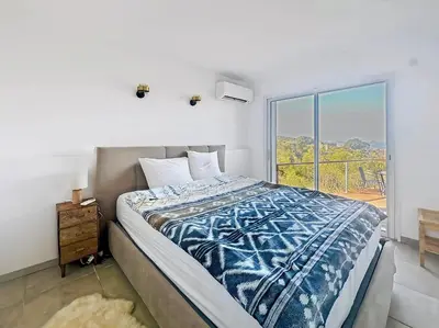 a bedroom with a bed and a large window at Superbe maison F5 avec vue mer - Plage à 5 min - Climatisation - Wifi gratuit in Grosseto-Prugna