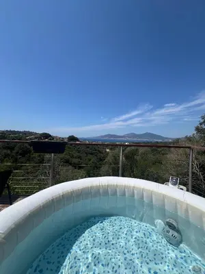 a jacuzzi tub on a balcony with a view at Superbe maison F5 avec vue mer - Plage à 5 min - Climatisation - Wifi gratuit in Grosseto-Prugna