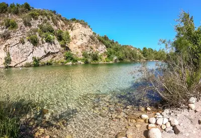 a body of water next to a mountain at Camping Sole Di Sari in Sari Solenzara