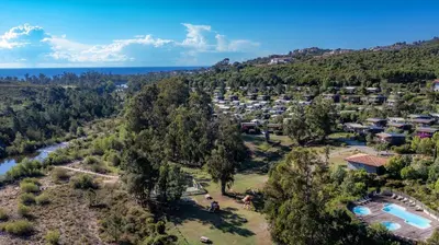 an aerial view of a resort with a river and trees at Camping Sole Di Sari in Sari Solenzara