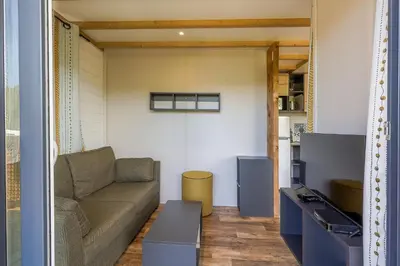 a living room with a couch and a table at Camping Sole Di Sari in Sari Solenzara