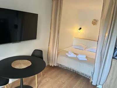 a small room with a bed and a table and a tv at Charmant Studio à Ajaccio in Ajaccio