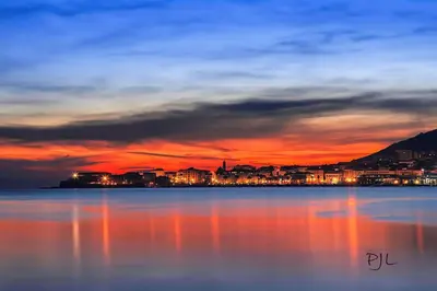 a view of a city from the water at sunset at Charmant Studio à Ajaccio in Ajaccio