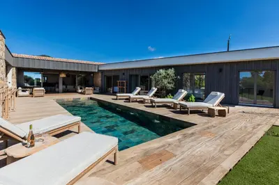 a backyard with a swimming pool and lounge chairs at luxury villa les Kiks 5 chambres, piscine chauffée, Lecci in Lecci