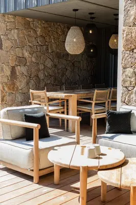 a patio with chairs and tables and a stone wall at luxury villa les Kiks 5 chambres, piscine chauffée, Lecci in Lecci
