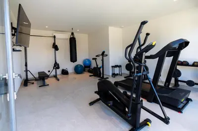 a gym with several treadmills and exercise bikes at luxury villa les Kiks 5 chambres, piscine chauffée, Lecci in Lecci