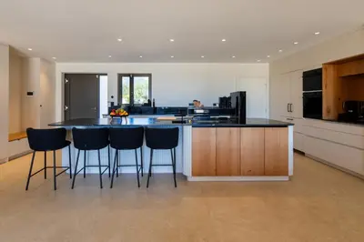 a kitchen with a large island with bar stools at luxury villa les Kiks 5 chambres, piscine chauffée, Lecci in Lecci