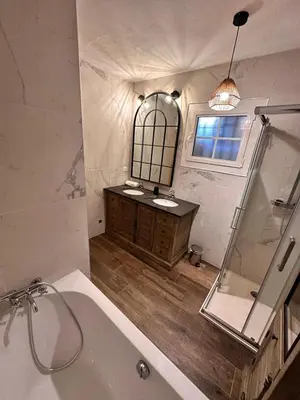a bathroom with a tub and a sink and a mirror at Villa Cala d Oro Vue mer Piscine et Crique privée in Sari Solenzara