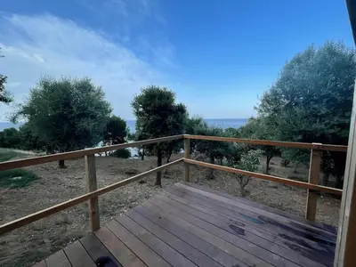 a wooden deck with a view of the ocean at Villa Cala d Oro Vue mer Piscine et Crique privée in Sari Solenzara