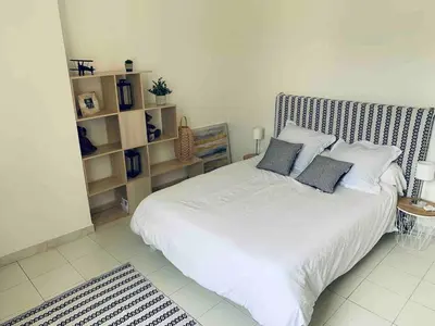 a bedroom with a large white bed with pillows at Appartement en centre ville in Corte