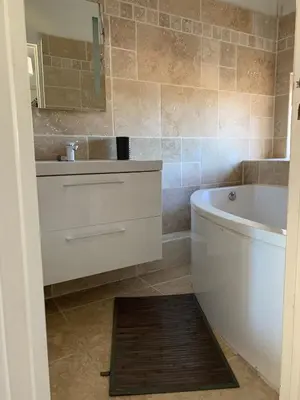 a bathroom with a sink and a tub and a mirror at Appartement en centre ville in Corte