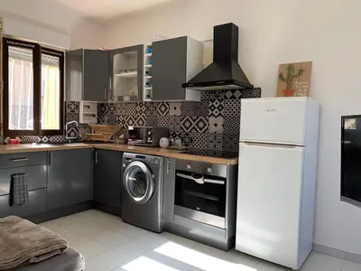 a kitchen with a washing machine and a refrigerator at Appartement en centre ville in Corte