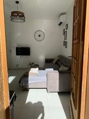 a living room with a couch and a clock on the wall at Appartement en centre ville in Corte