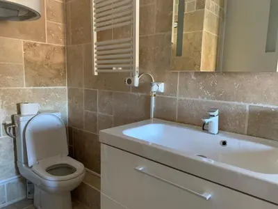 a bathroom with a toilet and a sink and a mirror at Appartement en centre ville in Corte