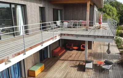an upper deck of a building with chairs and tables at Villa Ondella - Villa entre plages et sentiers in Pianottoli-Caldarello