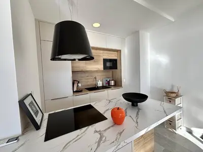 a kitchen with an orange vase sitting on a counter at F2 Vue mer le Neptune sanguinaires Ajaccio in Ajaccio