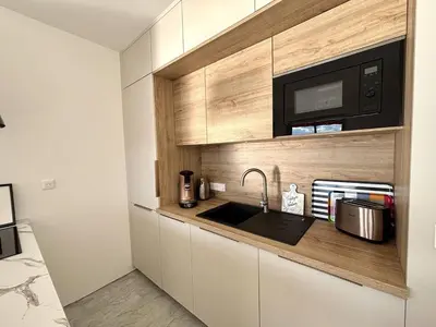 a kitchen with a sink and a microwave at F2 Vue mer le Neptune sanguinaires Ajaccio in Ajaccio