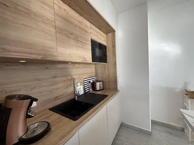 a kitchen with a sink and a coffee maker on a counter at F2 Vue mer le Neptune sanguinaires Ajaccio in Ajaccio