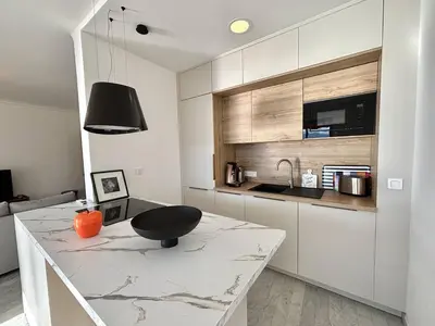 a kitchen with a counter with a black chair on it at F2 Vue mer le Neptune sanguinaires Ajaccio in Ajaccio
